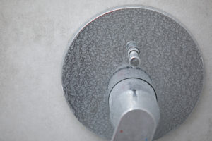 Dirty calcified shower mixer tap, faucet with limescale on it, plaque from water, Chrome-plated shower, close up photo.